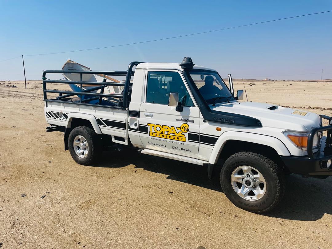 Topaz branded Land Cruiser carrying a boat across the desert